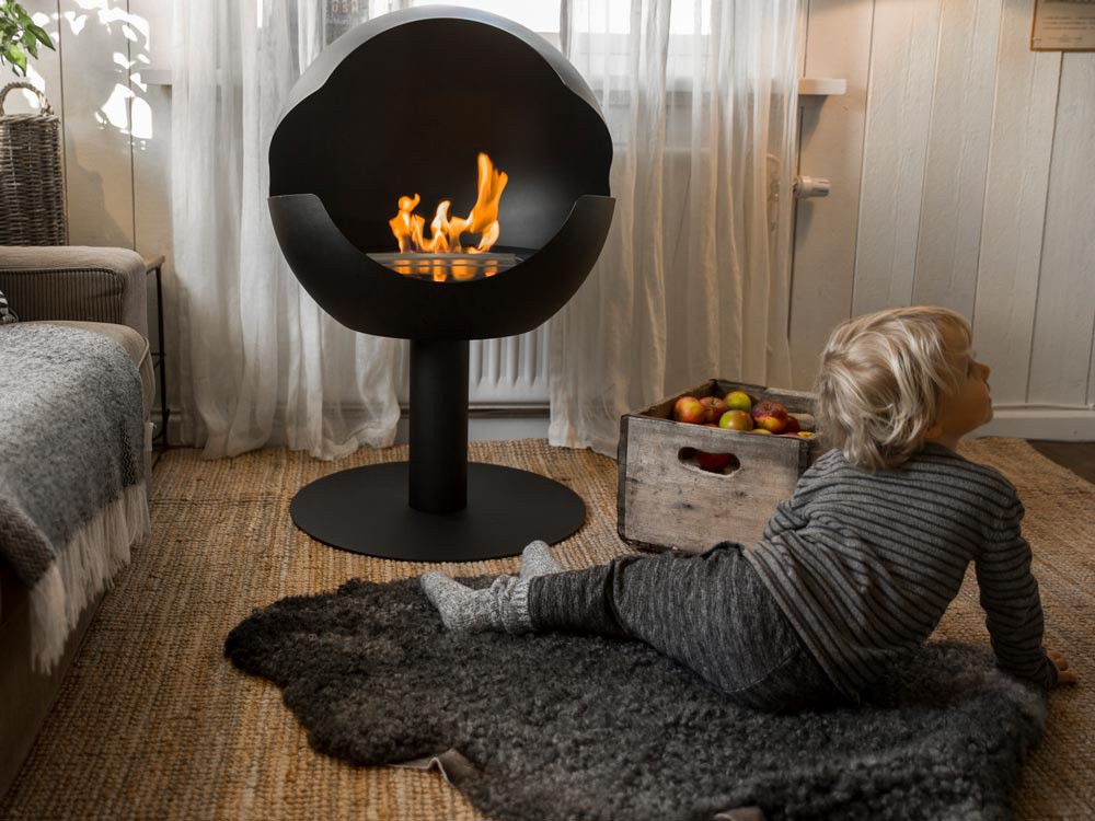 Little boy in front of a bioethanol fireplace